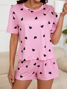 Close-up of pink women's pajama set featuring short sleeves and black heart print pattern