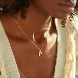 Elegant s925 silver double feather necklace in gold and silver finish on a female model