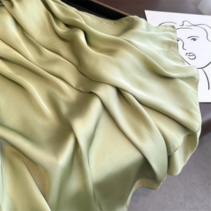 Elegant sage green satin long scarf draped gracefully on a minimalist studio backdrop