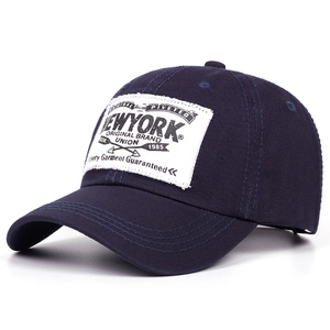 Detailed close-up of vintage New York letter print on navy blue cotton baseball cap