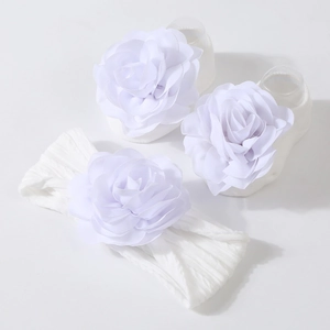 Détail de l'ensemble bandeau et chaussettes blanches pour bébé avec fleurs douces
