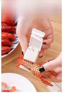 Practical crayfish peeling tool shown in action on a wooden table with fresh seafood