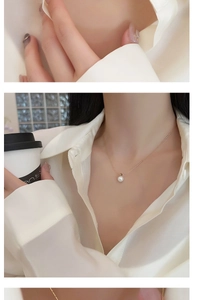 Elegant white pearl pendant on a fine gold chain worn by a model in a minimal setting
