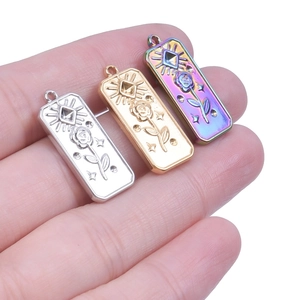 Detailed close-up of rose and sun patterns on gold, silver, and rainbow steel pendants