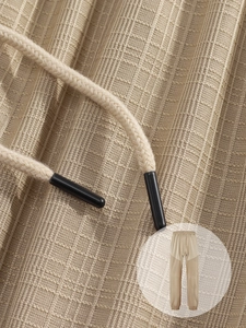 Detailed macro view of khaki waffle knit texture and drawstring on men's casual pants