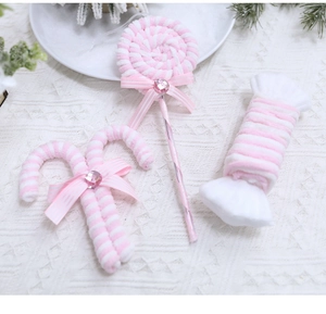 Detailed view of pink and white striped plush candy cane ornaments with ribbon bows