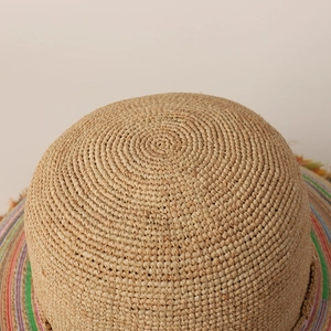 Detailed top view of handcrafted raffia sun hat showing spiral weave and rainbow trim