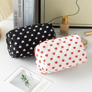 Detailed view of quilted cotton cosmetic bags with heart patterns in black and white