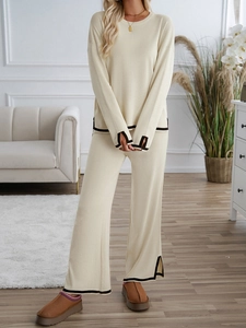 Close-up of knit lounge set with black piping detail on cream long sleeve top and pants