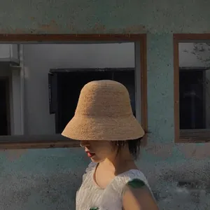 Detailed close-up showing the handmade raffia weave of the foldable summer sun bucket hat