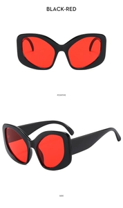 Detail view of black cat-eye sunglasses with red lenses showing front and side angles