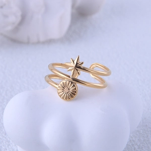 Detail of gold star and sun disk pendants on double-layered stainless steel ring