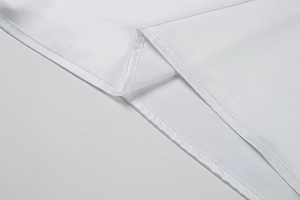 Detailed close-up of fine double-needle stitching on white silk fabric dress hemline