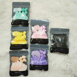 Set di 12 piumini da trucco triangolari in vari colori su sfondo in peluche morbido