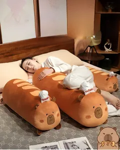 Capybara plush bread pillow in brown soft fabric shown with a model in a bedroom setting