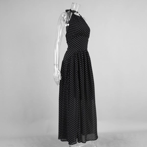Detailed close-up of polka dot pattern and halter neck design on a black maxi dress
