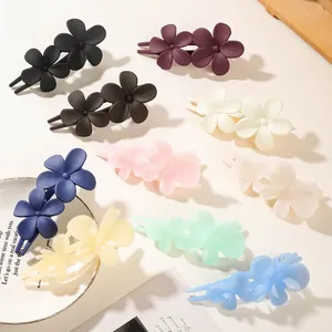 Detailed view of nine matte floral duckbill hair clips in various pastel colors and finishes