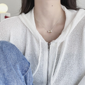 Close-up of minimalist S925 sterling silver triple interlocking ring pendant on neckline