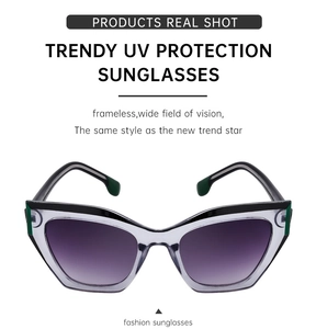 Detail of cat-eye sunglasses with transparent grey frame and green temple accents