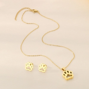 Gros plan d'un ensemble collier et boucles d'oreilles dorés en inox avec pattes de chat