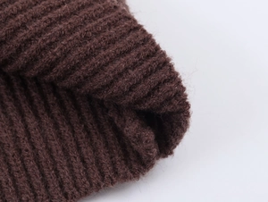 Detailed close-up of dark brown rib-knit fabric texture with soft wool blend fibers