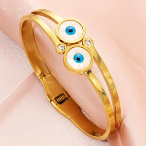 Gold stainless steel double-layer evil eye spring cuff bracelet on pink satin cloth