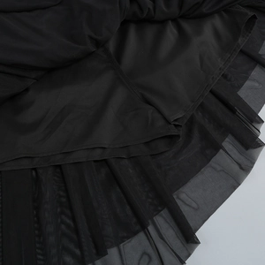 Close-up of black mesh skirt detail showing layered fabric texture and sewing craftsmanship