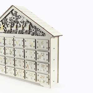 Macro detail of wooden 24-day Christmas advent calendar house with snowflake carvings
