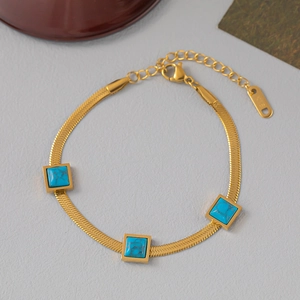 Dettaglio della collana a catena serpente oro con pietre turchesi e incisione K18