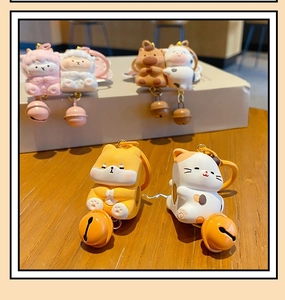 Close-up of cute resin animal keychains with colorful metal bells on wooden surface