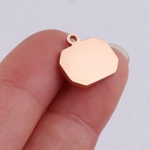 Close-up of a hand holding a rose gold geometric polygon pendant for DIY jewelry