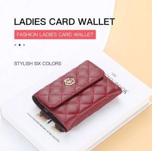 Detail of red quilted PU leather card holder with gold star ornament on a white book