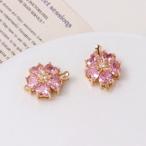 Close-up of pink cherry blossom jewelry connectors with heart-shaped petals and gold base