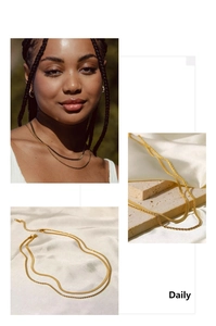 Close-up of layered gold necklace featuring flat snake chain and rope chain details