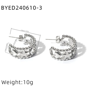 Macro detail of stainless steel C-shaped earrings with star heart hollow patterns