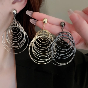 Detail of multi-layered metallic hoop earrings in silver, gold, and gun black finishes