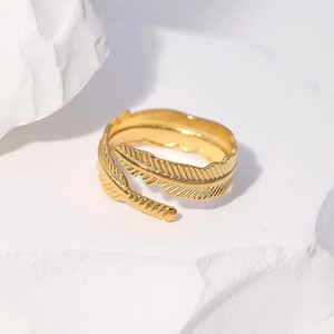 Detailed macro view of gold feather open ring showing intricate metallic texture on stone