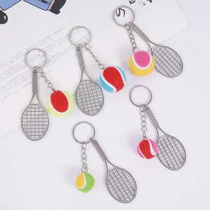 Détail de porte-clés mini raquette de tennis avec balles colorées sur un livre