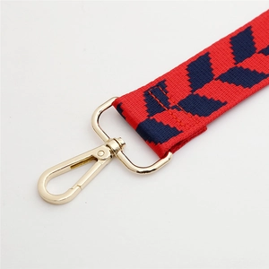 Adjustable jacquard bag strap with blue leaf pattern on red fabric and gold metal hooks