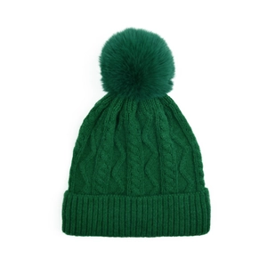 Detailed knit pattern and faux fox fur pompom on dark green winter beanie hat