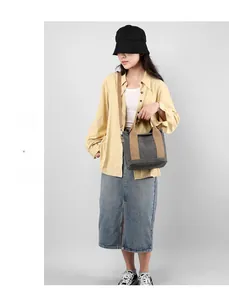 Grey canvas tote bag shown with a long shoulder strap and durable wide webbing handles