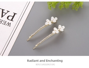 Detail of two-piece gold hair clips with drop-shaped pearls and sparkling rhinestones