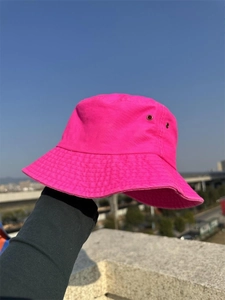 Detail of pink cotton canvas bucket hat showing texture and vibrant neon color