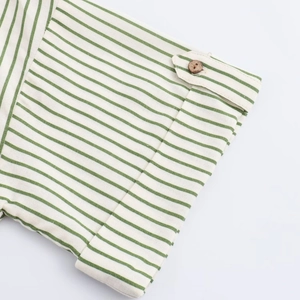 Détail d'une manche de chemise rayée verte avec texture lin et bouton en bois
