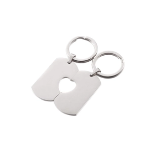 Close-up of polished stainless steel puzzle heart keychains for couples in silver