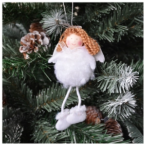 Close-up of white plush angel ornament hanging on a Christmas tree with pine cones
