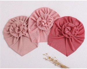 Detail of baby turban hats with 3D handmade flowers in light pink and metallic elastic fabric