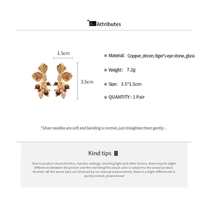 Detailed view of flower earrings with zircons, tiger eye beads and silver needles