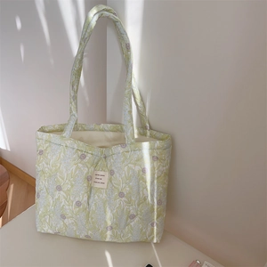 Detailed close-up of French floral quilted tote bag with textile woven label