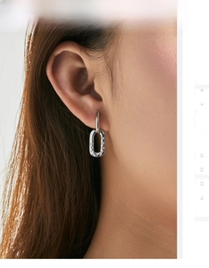 Close-up of S925 silver geometric hoop earrings with pavé zircons on a model's ear